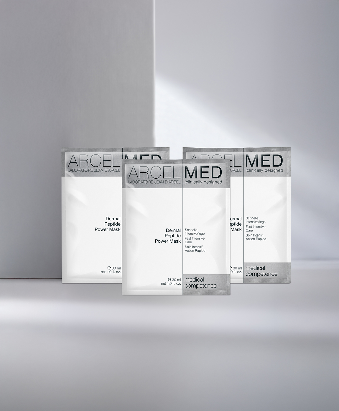 Drei JEAN D'ARCEL Dermal Peptide Power Mask stehen nebeneinander auf grauem Hintergrund.